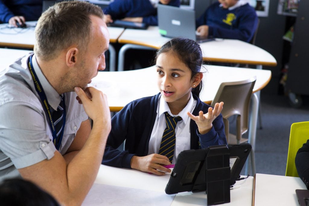 teacher helping a pupil with classwork